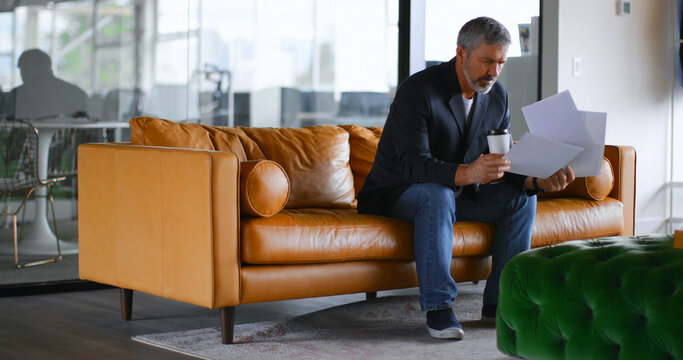 Caucasian businessman reading documents working in creative office with copy space