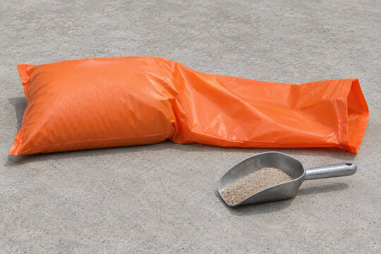 Partly filled synthetic sandbag beside a metal sand scoop