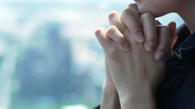 woman hands clasped together in prayer, side view. Concept of faith, hope, spirituality, and religious devotion.