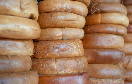 Smoked Sulguni cheese wheel background. Traditional Georgian dairy product stack