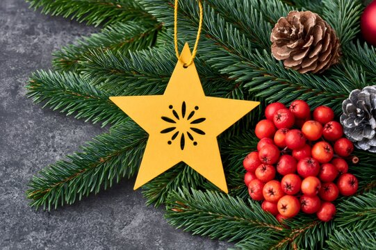 Christmas star ornament with red berries and pinecones on evergreen branches
