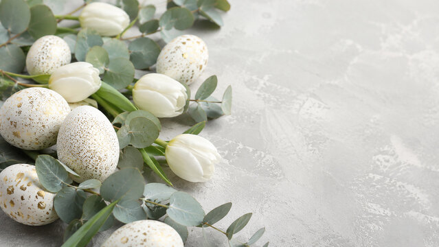 Elegant Easter Setup With Speckled Golden Eggs And White Tulips On Grey
