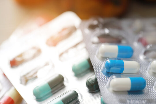 pills capsule on to surface tablets. drug medical healthcare pharmacy concept. pharmaceuticals antibiotics medicine in blister packs.	
