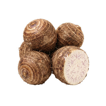 Round brown taro roots with one cut half showing pale flesh