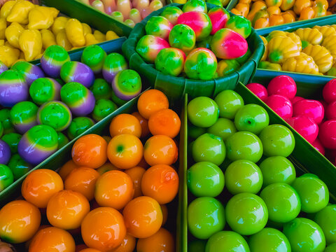 Colorful Look Choup traditional Thai mung bean marzipan dessert arranged in tray. Traditional Thai dessert made from sweetened mung bean paste shaped like miniature fruits with glossy colorful glaze,