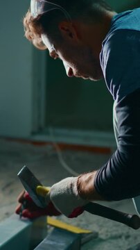 Focused Craftsman Working Intently with Hammer and Tools in Dimly Lit Environment, Capturing the Art of Handwork and Attention to Detail in Construction