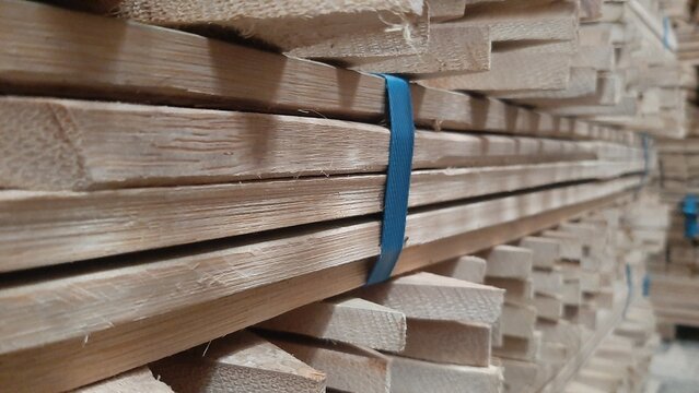 Stacked wood planks, neatly bundled with blue ties