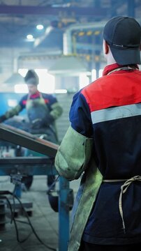 Workers Operating Machinery in a Manufacturing Facility: Precision Fabrication and Safety Procedures in a Modern Industrial Environment
