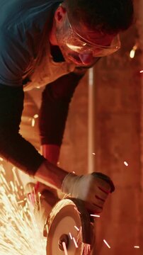 Skilled Worker Using Angle Grinder to Cut Metal with Sparks Flying in Dimly Lit Workshop, Demonstrating Craftsmanship and Focus on Safety Measures