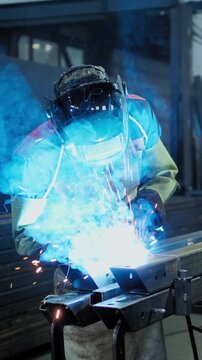 Welding in Action: A Skilled Technician Uses a Welding Torch to Join Metal Pieces Together, Creating Bright Sparks and Smoke in a Workshop Environment