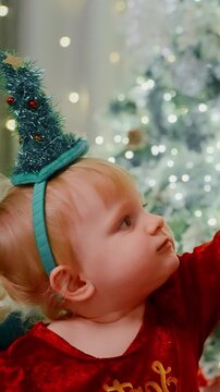 Adorable Child in Holiday Outfit with a Sparkling Christmas Tree Headband Enjoying Festive Moments During a Cheerful Celebration Filled with Joy and Laughter