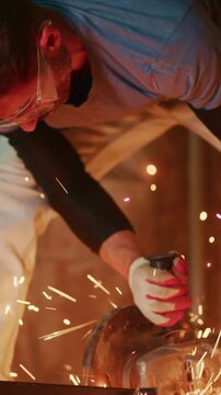 Worker Engaged in Metal Cutting Process with Safety Gear Amidst Sparks and Intense Focus on Precision in a Workshop Environment