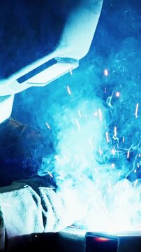 Igniting the Flame: A Close-Up of a Welder Creating Sparks and Illuminating Smoke in a Craftsmanship Display of Heat and Precision in Metalworking.