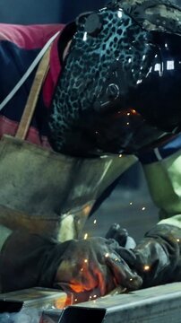 A Dedicated Welder Skillfully Engaged in Metal Fabrication, Creating Sparks and Fumes, Highlighting the Precision and Craftsmanship of the Welding Process