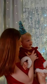 A Joyful Holiday Moment: A Mother and Child Celebrate Together with Festive Decorations and Lights, Creating a Heartwarming Scene Full of Love and Cheer