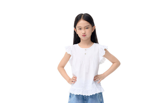 Pouting young girl standing with hands on hips in white blouse