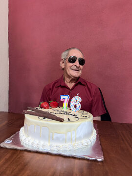 Senior adult celebrating 76th birthday with cake and candles