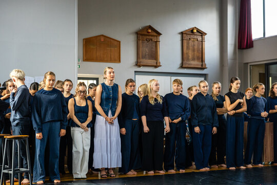 Dance company lined up barefoot in the rehearsal hall
