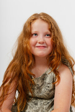 Girl With Long Red Hair Smiling in Studio Setting