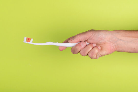 Hand holding toothbrush  on a green background