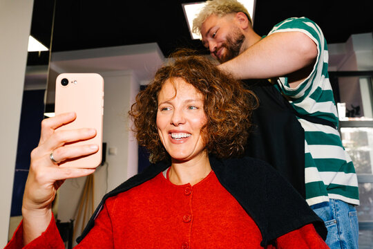 Woman taking selfie during salon appointment