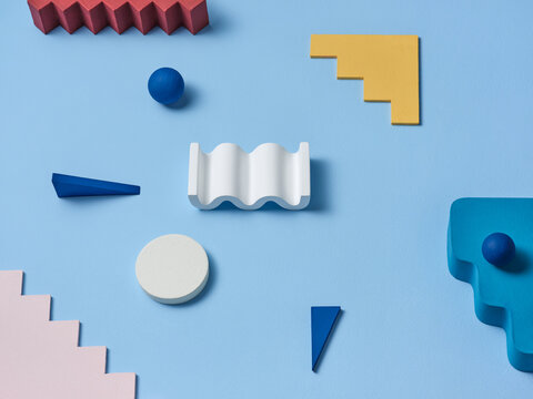 Various colorful geometric shapes are artfully arranged on blue