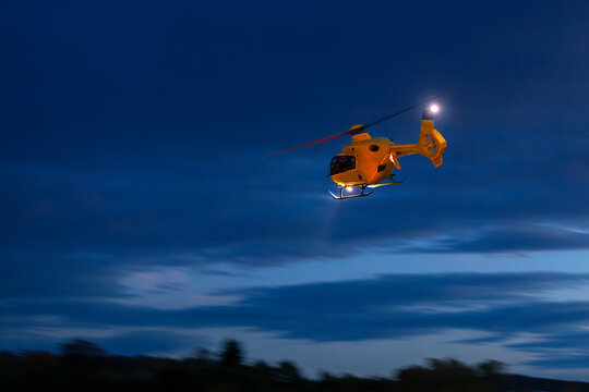 Emergency medical service rescue helicopter flying in dark night sky. Themes rescue, help and hope.