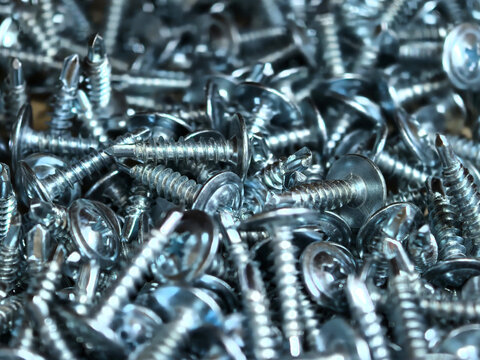 Silver screws gather in a shimmering metal heap
