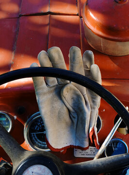 gants de travail  , tracteur rouge , travaux des champs, style de vie , afterwork , gants us&eacute;s , cuir  patin&eacute; , tableau de bord , histoire de vie , gros plan , vintage , aujourd'hui 