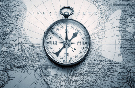 Magnetic old compass and rope on old nord pole map. Travel, geography, history, navigation, tourism and exploration concept background. Retro compass on geography map.
