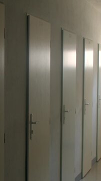 Dimly lit school corridor with row of closed classroom doors in Czech