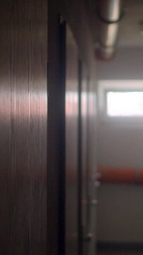 Narrow school corridor with wooden lockers and soft daylight viewing