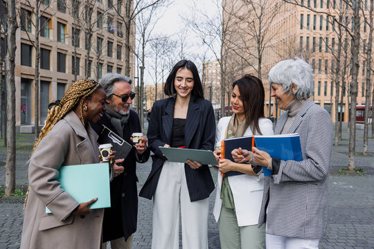 multiracial and diverse business adult group of people together in a winter morning outdoors at cityscape. Successful Entrepreneurs multigenerational teamwork in city urban scene 