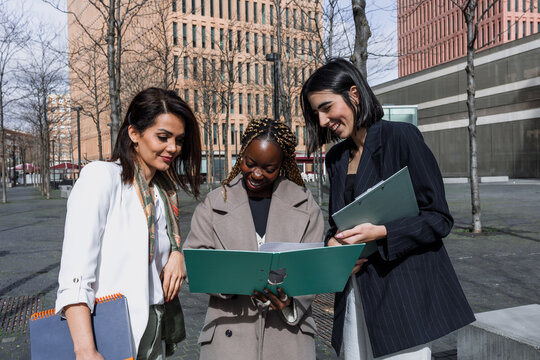 diverse business adult women together in a winter morning outdoors at cityscape. Successful Entrepreneurs multigenerational and multiracial female teamwork in city urban scene 