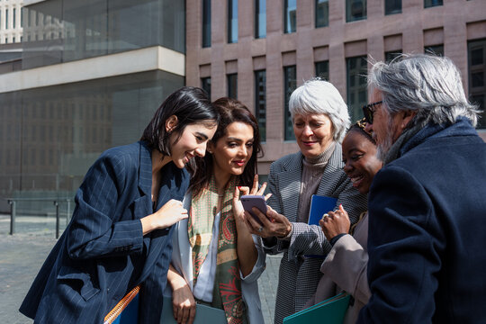 multiracial and diverse business adult group of people together in a winter morning outdoors at cityscape. Successful Entrepreneurs multigenerational teamwork in city urban scene 