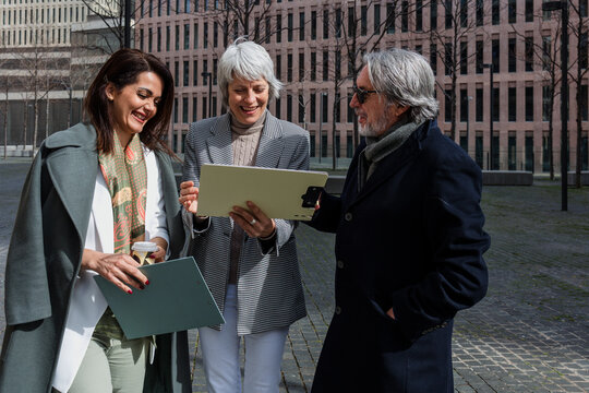 multiracial and diverse business adult group of people together in a winter morning outdoors at cityscape. Successful Entrepreneurs multigenerational teamwork in city urban scene 