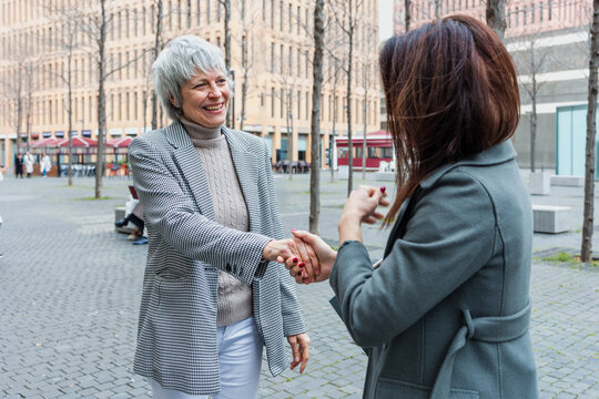 diverse business adult women together in a winter morning outdoors at cityscape. Successful Entrepreneurs multigenerational and multiracial female teamwork in city urban scene 