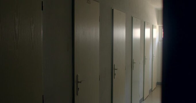 Empty school corridor with numbered classroom doors and soft light inC