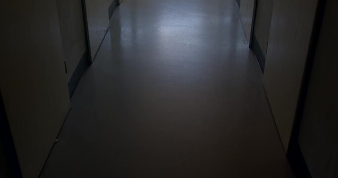 Dim school corridor with polished linoleum floor and closed classroom