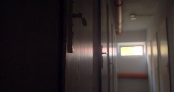 Closeup wooden locker handle in dim school corridor with distant light