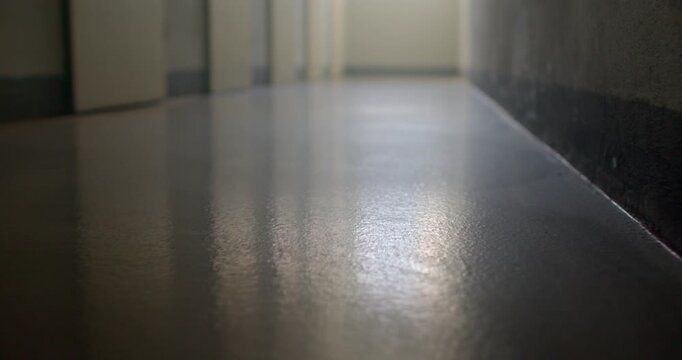 Low-angle corridor floor reflecting soft daylight in empty interior