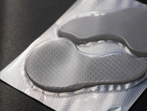 Under Eye Gel Patches in Sealed Blister Packaging on Dark Background