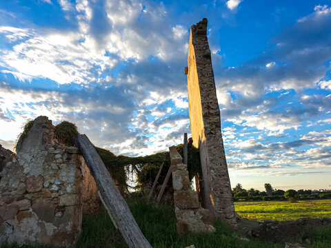 Ruins of an Ancient Stone Farmhouse Wall Under a Dramatic Blue S