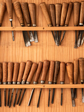 Vintage Wood Carving Chisels and Gouges on a Wooden Tool Rack in