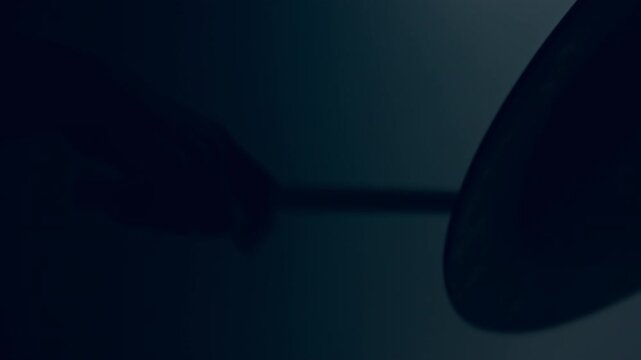Drummer hitting cymbal close up. Silhouette hand drumstick rock music dark.