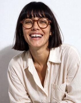 Portrait of a woman in her 20's wearing eyeglasses laughing