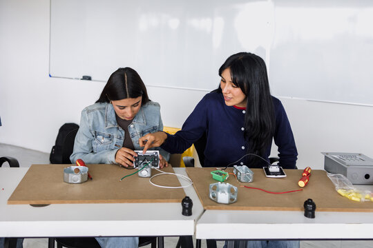 two latin american young women students in an electricity class or electrical circuits at university in Mexico