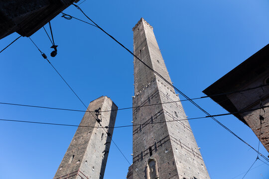 Low angle view of Asinelli and Garisenda medieval towers against a blue sky in Bologna, Italy