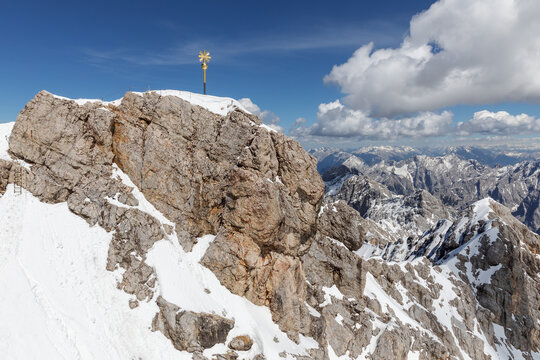 Gipfel der Zugspitze, h&ouml;chster Berg in Deutschland, mit dem Gipfelkreuz, rechts davon der Jubli&auml;umsgrat, dahinter weitere Gipfel der Alpen, Himmel mit Quellwolken
