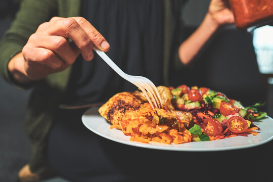 Fork Pressed into Kimchi Beside a Chicken Drumstick on a Plate